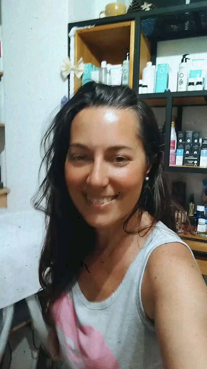 Geo sonriendo en su gabinete de Olivos, con la camilla y los estantes de productos detrás